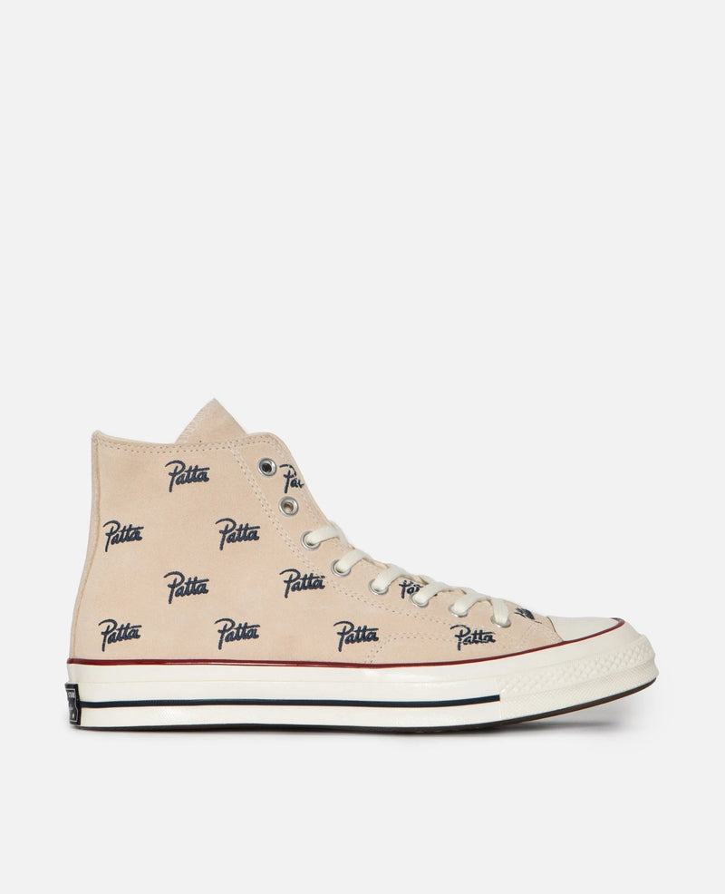 Side profile of the Patta x Converse Chuck 70 Hi sneaker in Natural Ivory canvas with blue script logos.